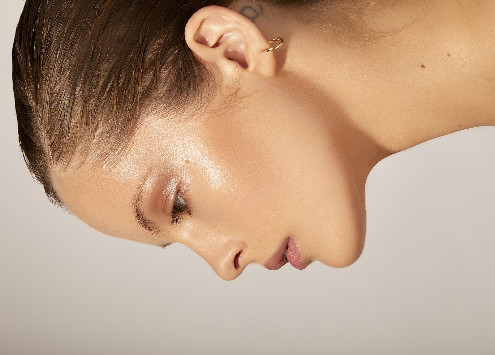 Close-up of a person with wet hair and gold hoop earring