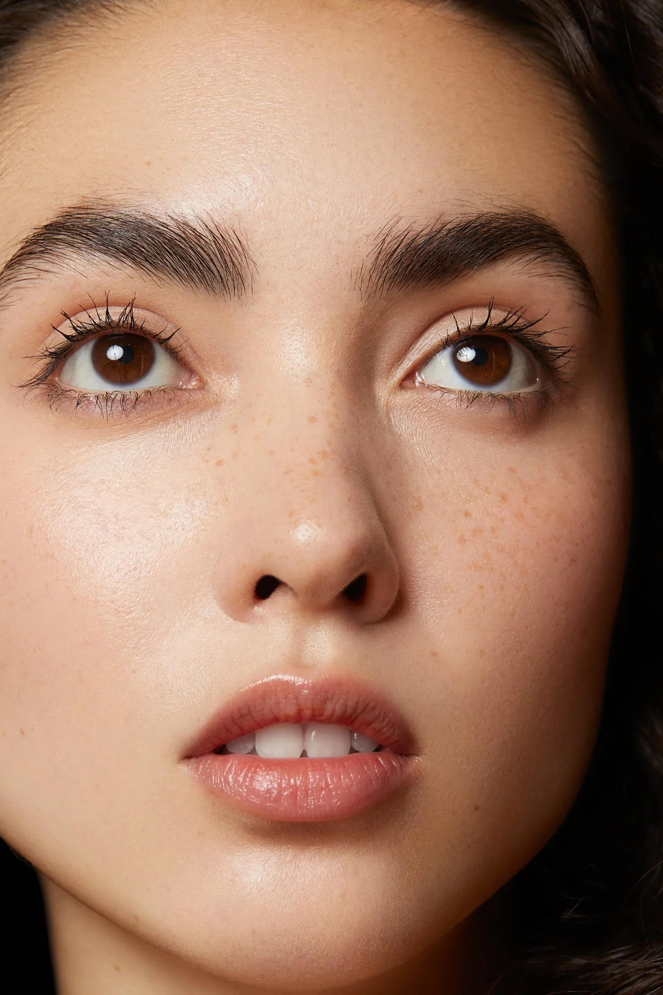 Beauty extreme close-up of a model's eyes and lips with natural dewy skin, highlighting fresh complexion for a skincare and beauty campaign by Adrianna Favero, NYC beauty photographer and director.