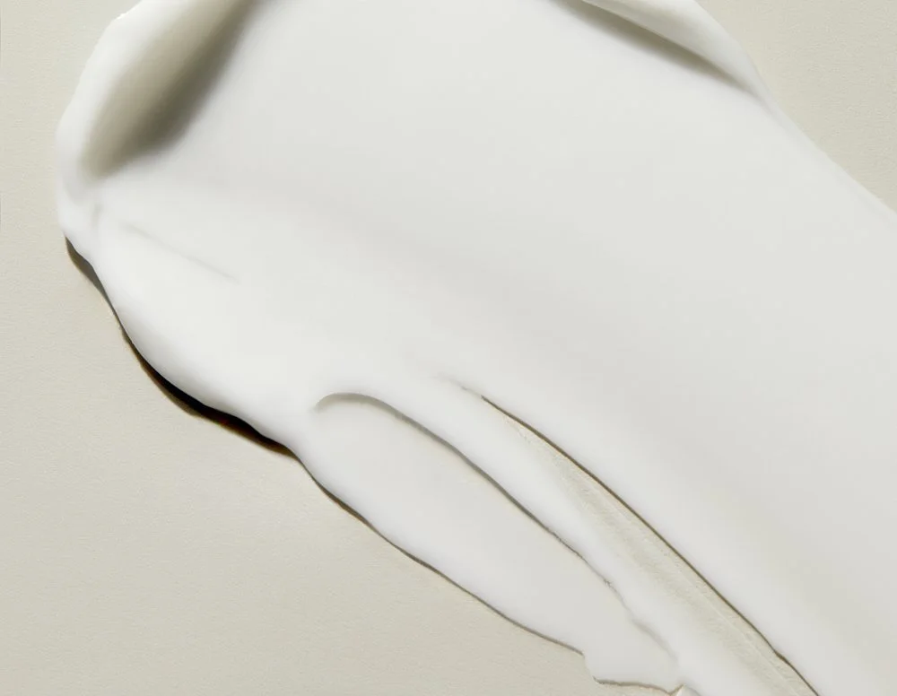 Close-up texture shot of white cream swirled with a dark edge, by Adrianna Favero.