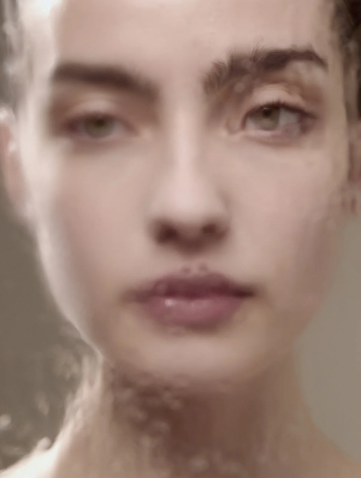 Beauty close-up portrait of a model's face with natural makeup and clear skin against a neutral background, for a skincare and beauty editorial campaign by Adrianna Favero, NYC beauty photographer and director.