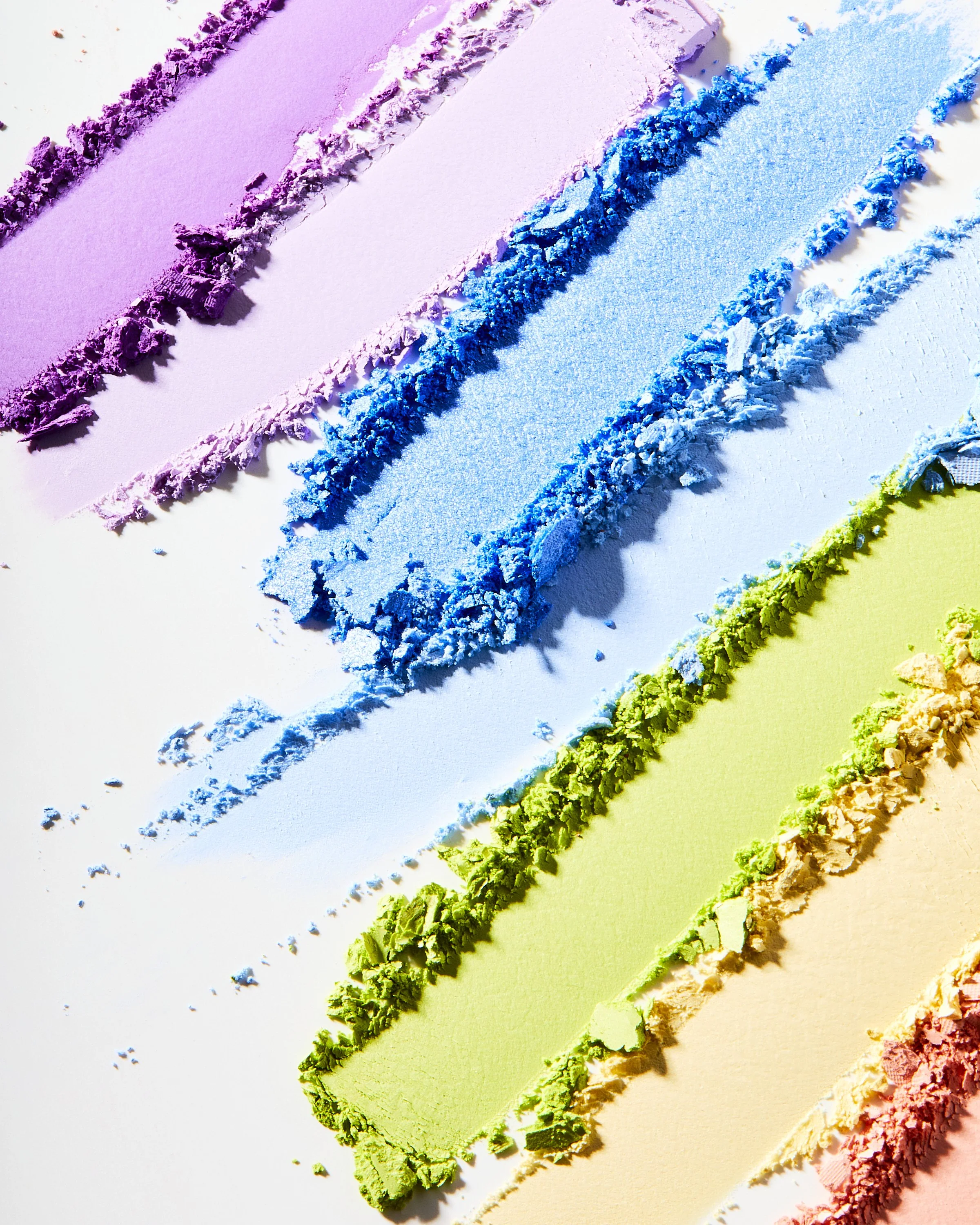 Eyeshadow swatch texture in diagonal stripes of purple, blue, and green, by Adrianna Favero.