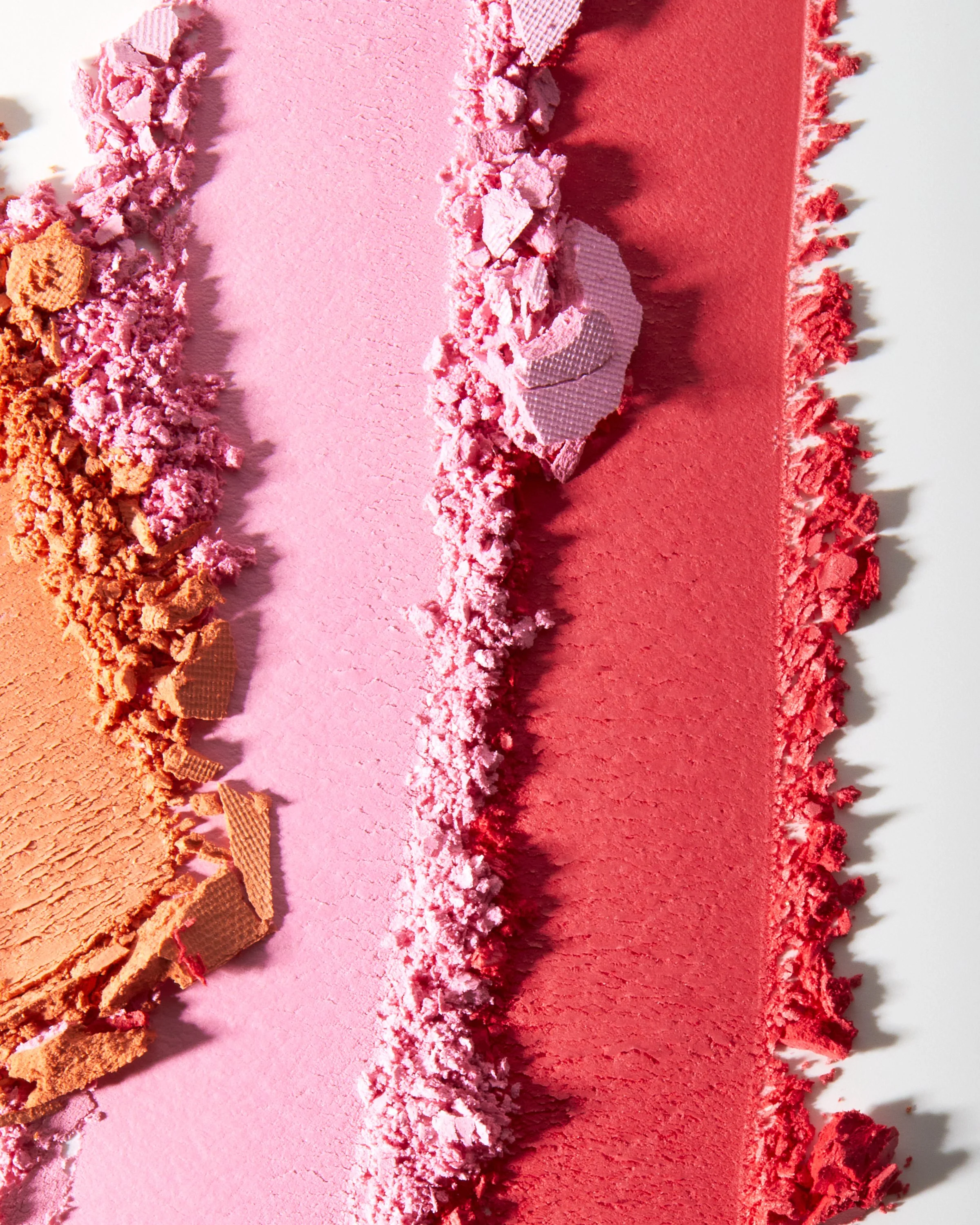 Close-up texture shot of a small cosmetic product on coral pink fuzzy fabric, by Adrianna Favero.