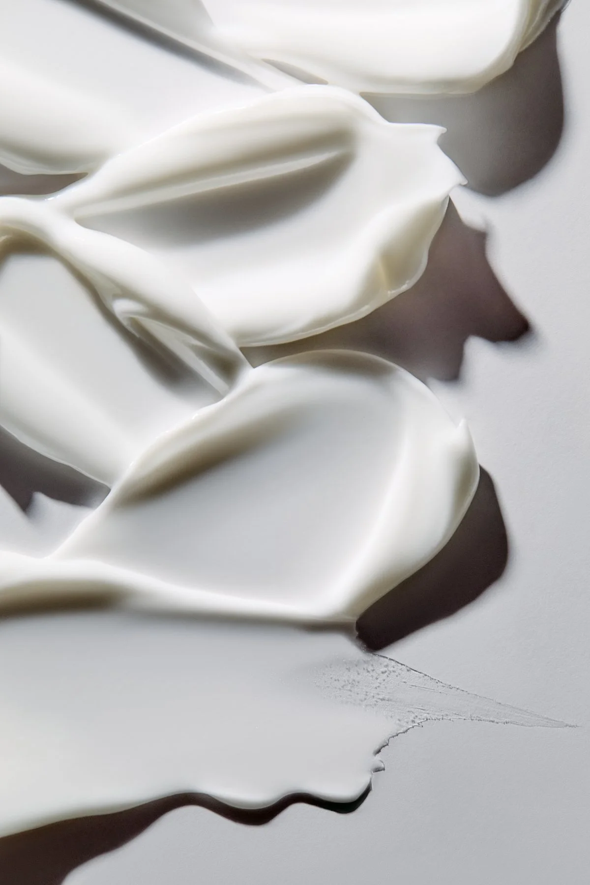 Close-up texture shot of white cream swirled with a dark brown streak, by Adrianna Favero.