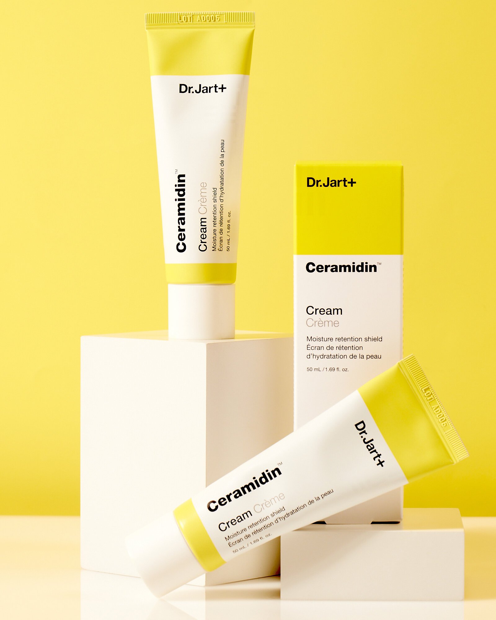 Three Dr. Jart+ Ceramidin Cream tubes and box on a yellow background.