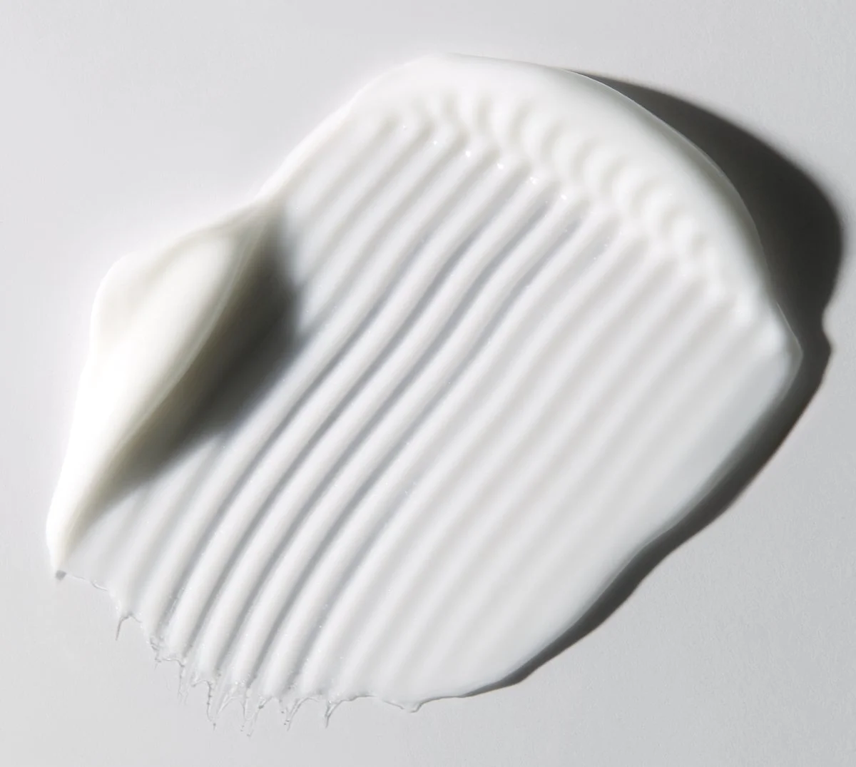 Close-up texture shot of ribbed white cream with a dollop on top, by Adrianna Favero.