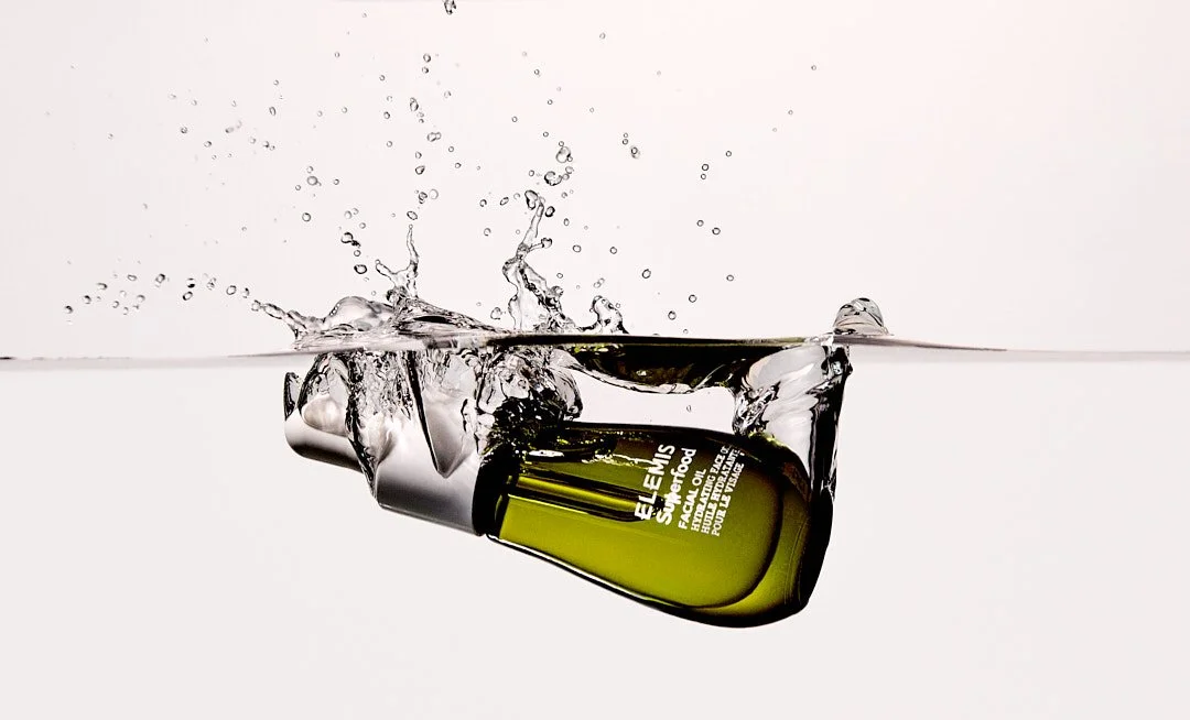 Still life splash image of Elemis Superfood Serum by Adrianna Favero, NYC-based beauty still-life photographer and director. Capturing dynamic motion and fresh skincare aesthetics—ideal for luxury beauty campaigns, product launches, and editorial fea