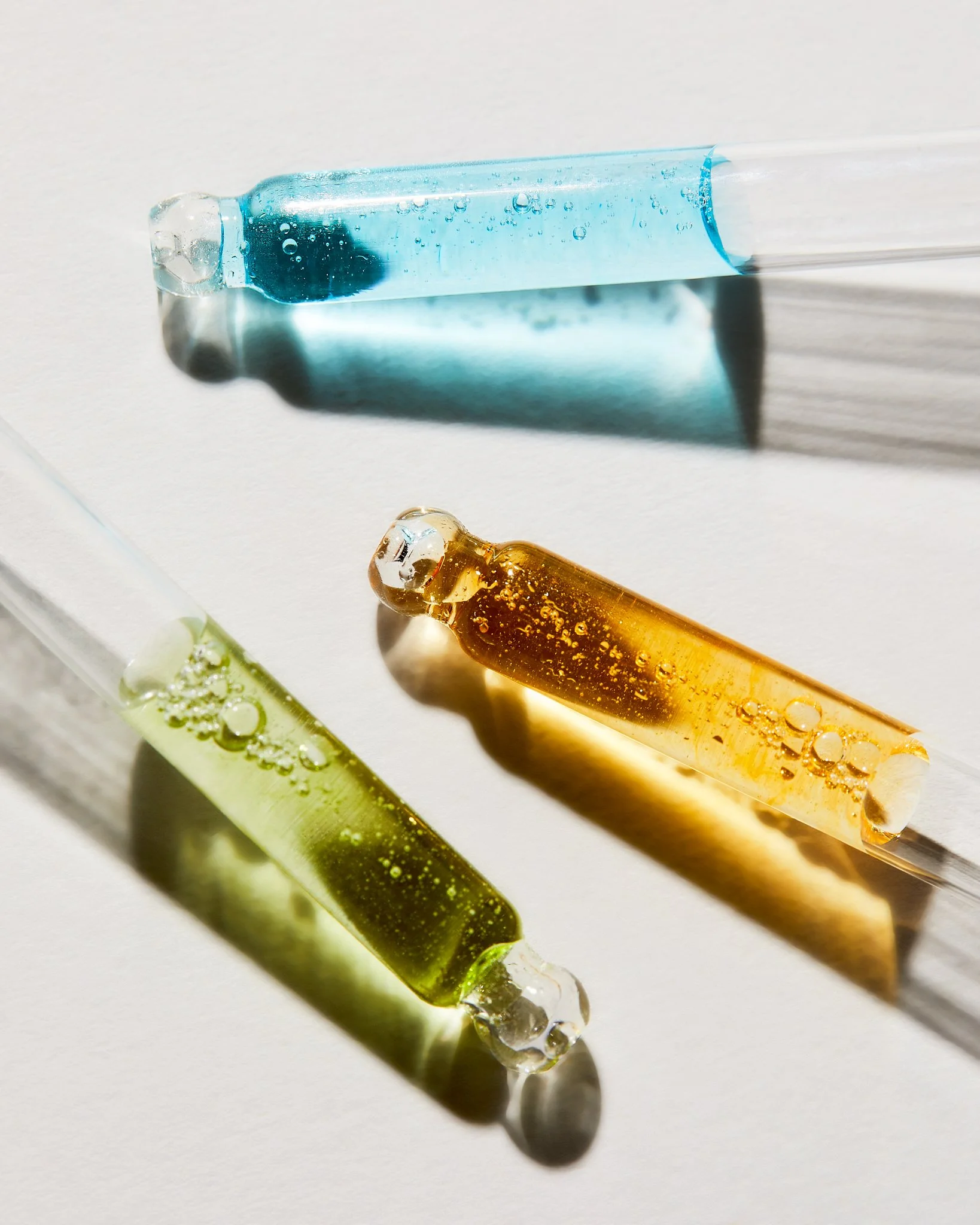 Still life of two droppers with colored serums by Adrianna Favero, NYC-based beauty photographer and director. A clean, modern composition highlighting skincare actives—ideal for beauty branding, campaigns, and product storytelling.