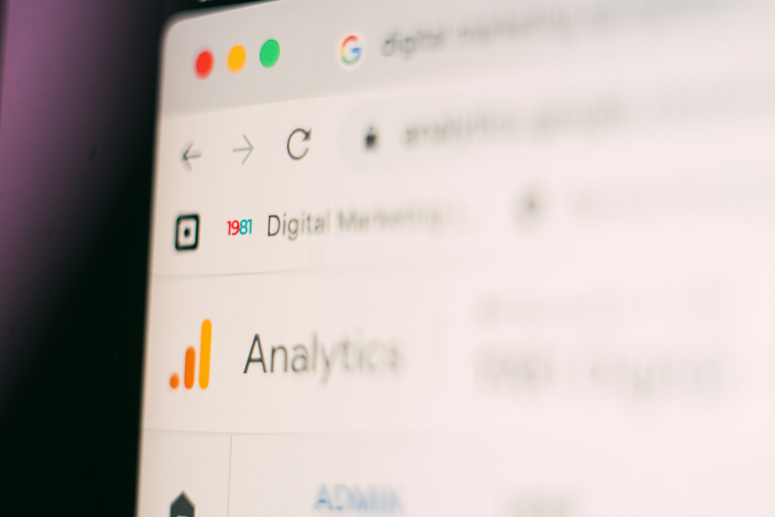 Close-up of a laptop screen displaying a blurred web browser with icons and text, including the Google icon and the word 'Analysis'.