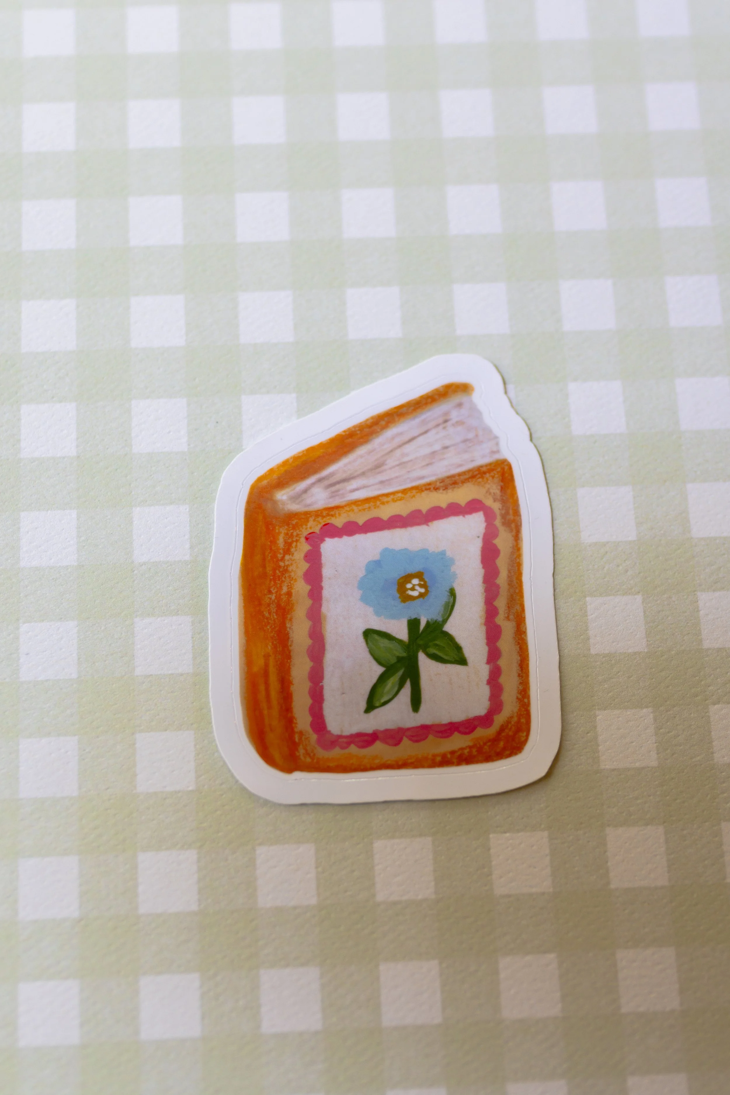Blue Blossom Storybook die cut sticker featuring an original hand-illustrated vintage-inspired book with a blue flower on the cover.