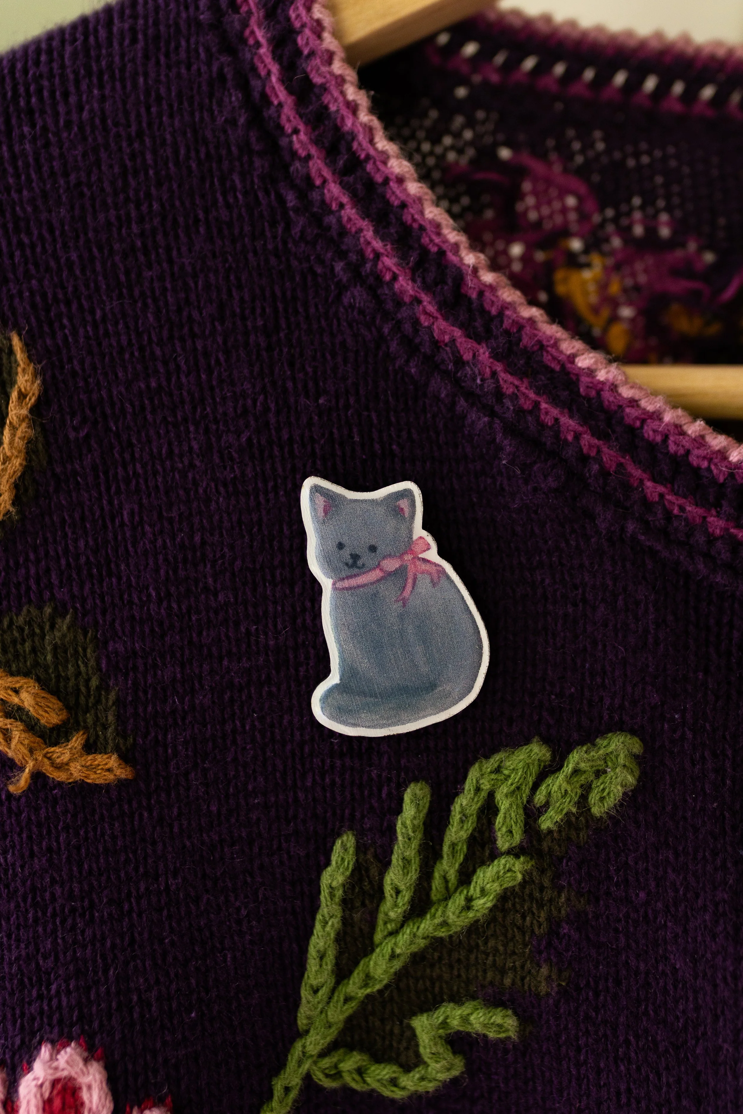 George the Garden Cat wooden pin featuring an original hand-illustrated Russian Blue cat wearing a pink bow.