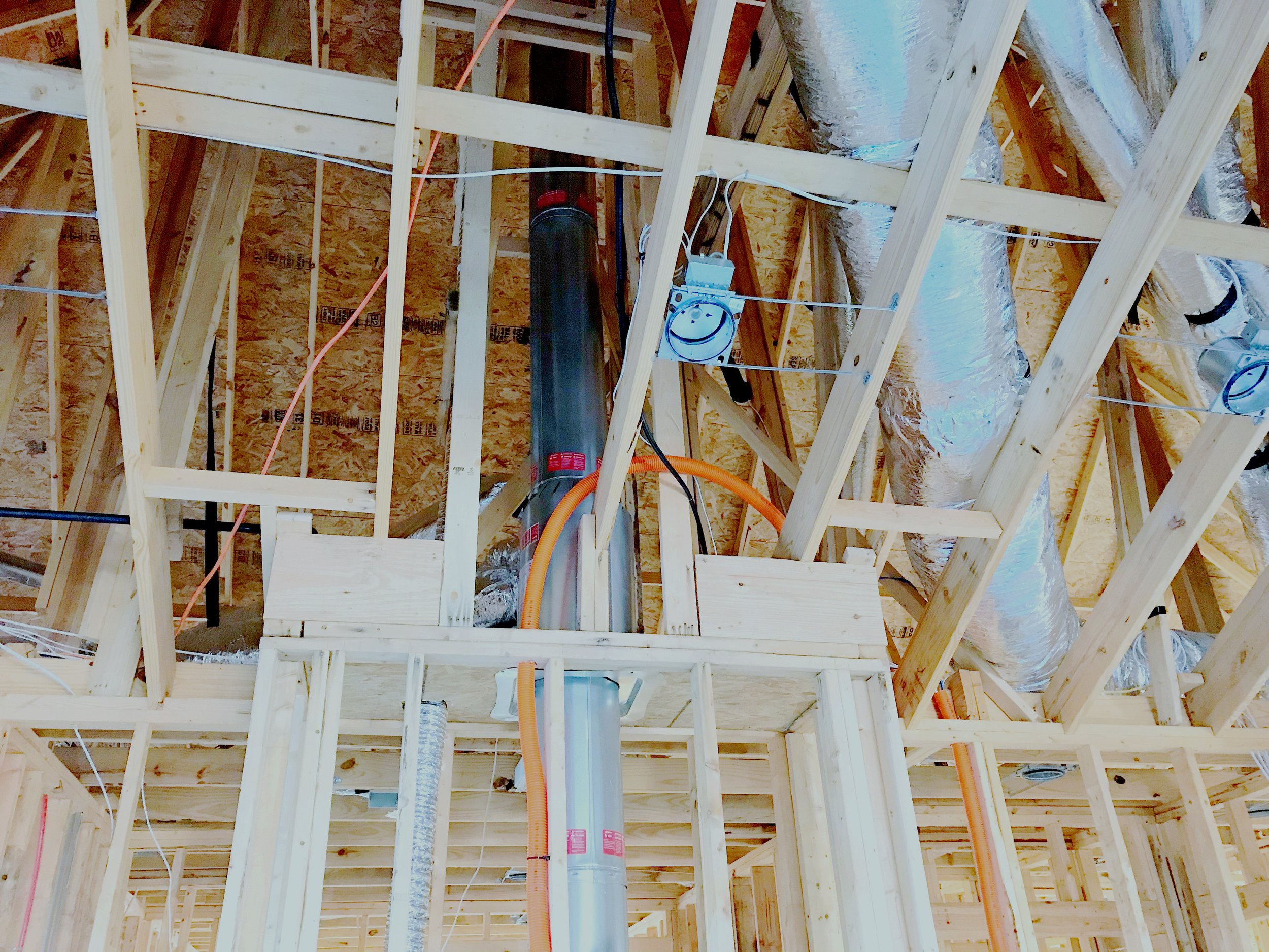 Cable conduit ran through the rafters of a custom home attic near the fireplace.