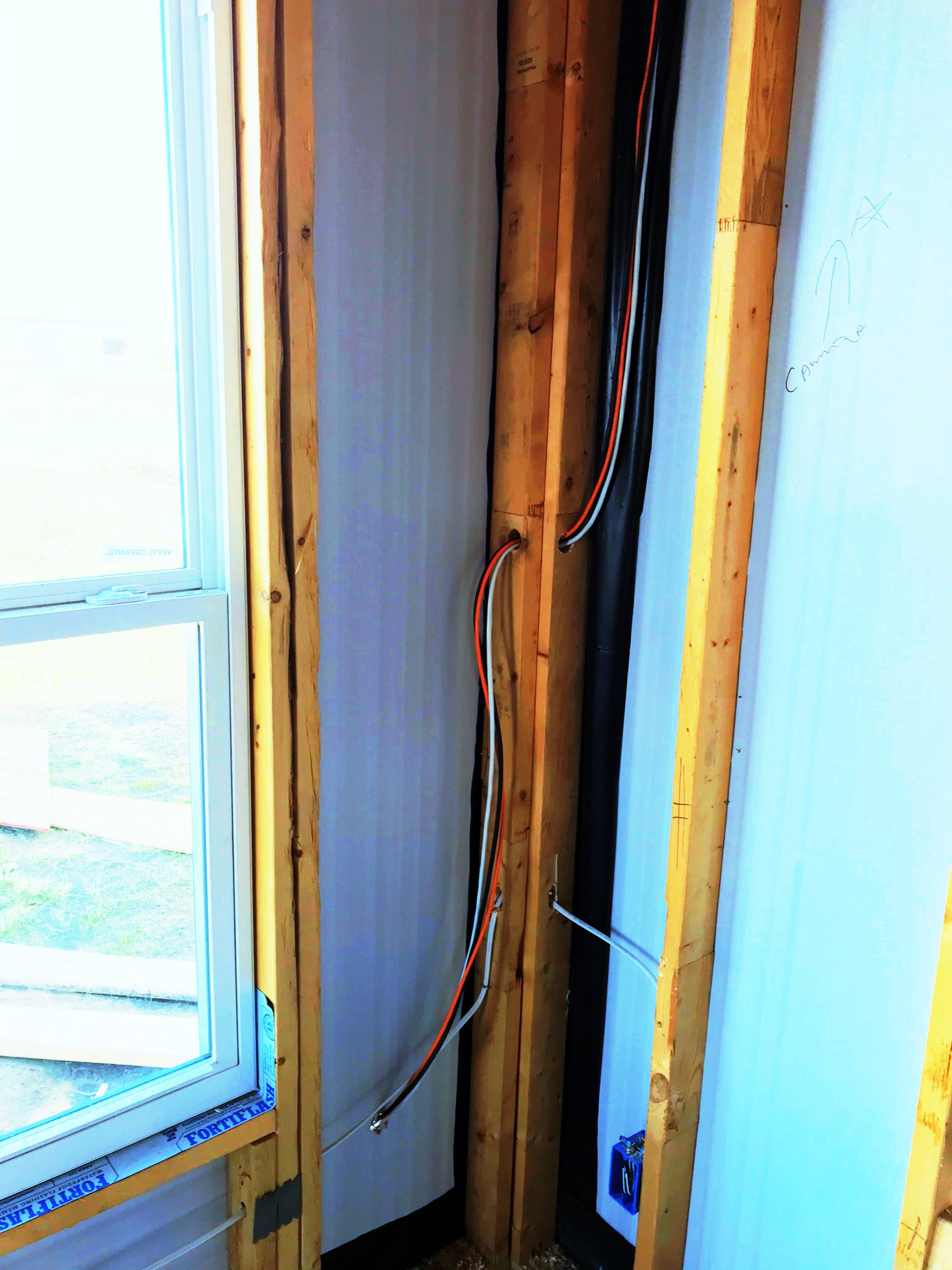 Network cables run through the corner 2x4 of a home.