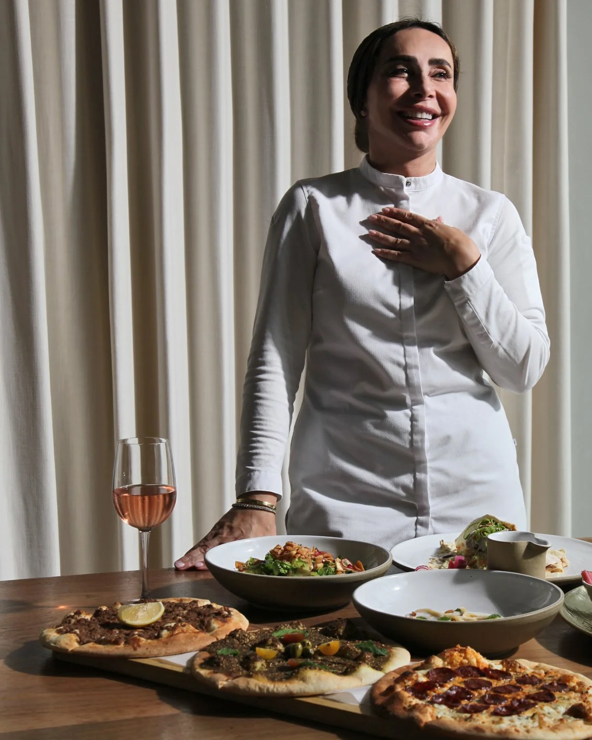 alt="Chef Dima Habibeh smiling in the dining room at Ammatolí"