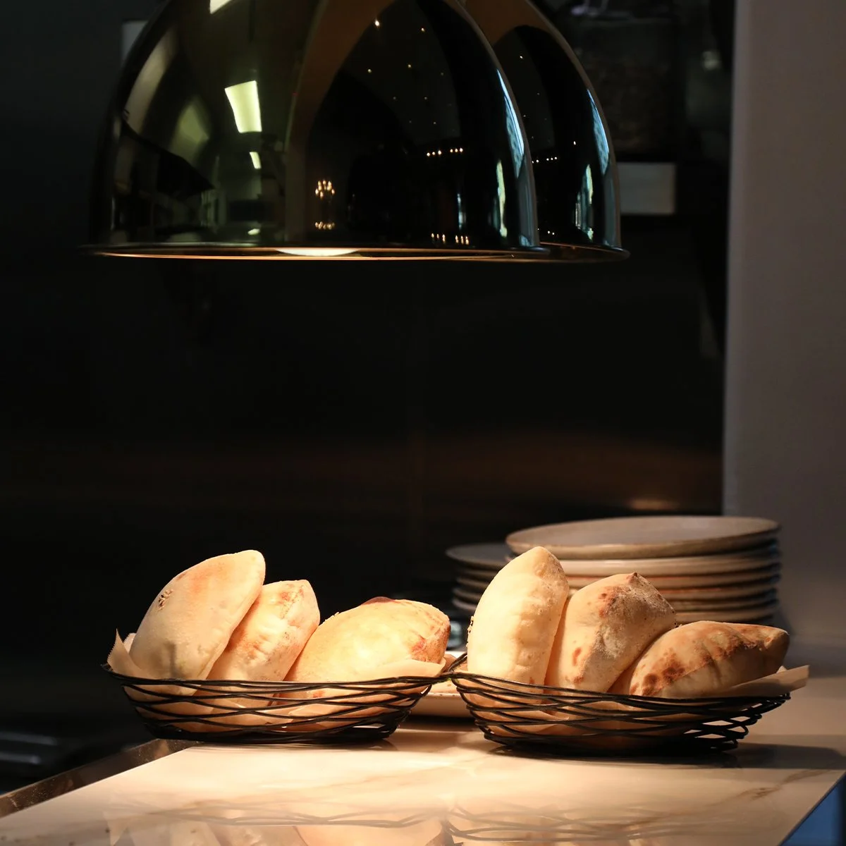 alt="Freshly baked hot from the oven sitting underneath a heat lamp"