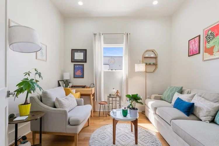 private commercial office rental new orleans white couches white rug coffee table natural light framed artwork desk tables 
