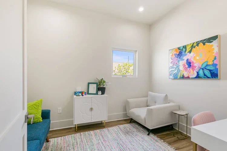 private commercial office space for rent white sofa loveseat colorful white rug white table with drawers coffee table natural light white walls framed art blue sofa