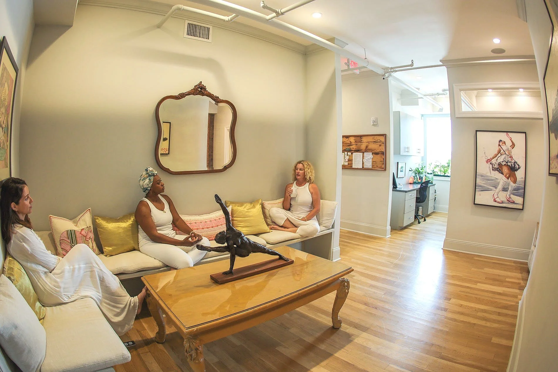 women talking lobby dancer sculpture couch mirror coffee table interior design