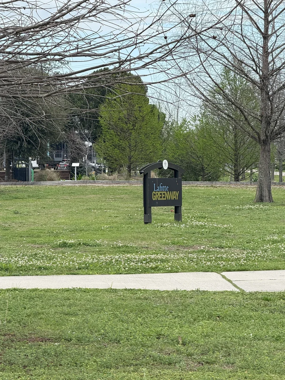Lafitte Greenway sign in New Orleans, Louisiana with a black sign and green grass open park for walking and breaks next to private commercial office rental space 