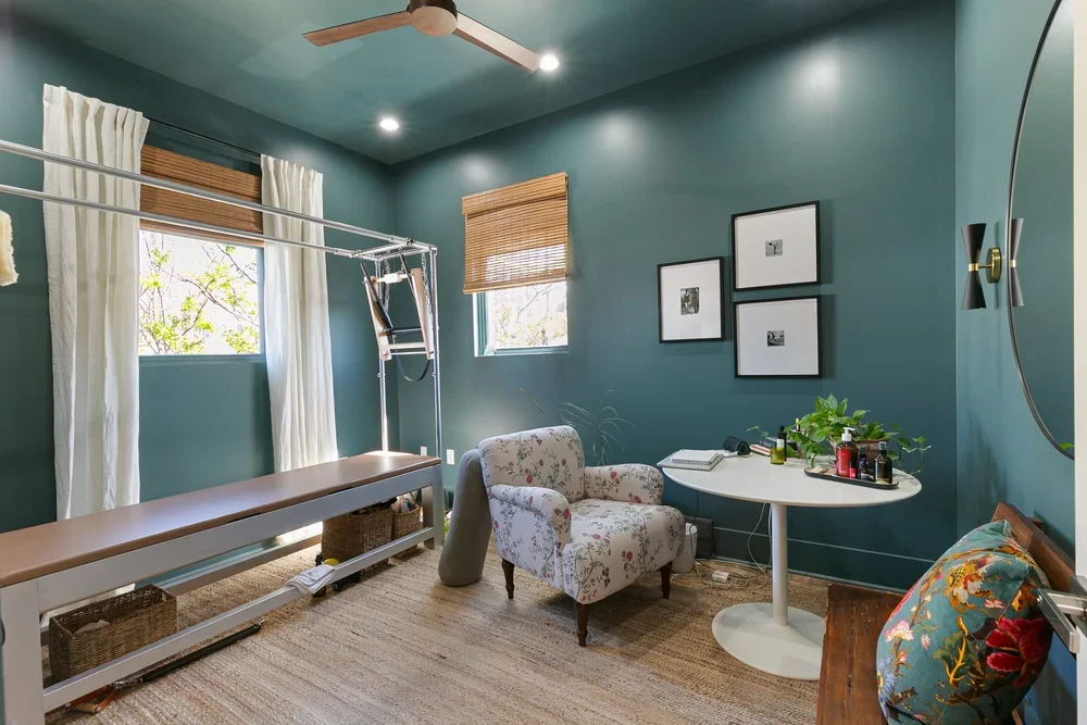 private commercial office rental new orleans reformer pilates private pilates studio armchair rattan curtains natural light white table wood floors ceiling fan boutique