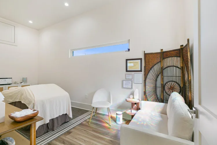 massage therapist private new orleans boutique rental space office space commercial office white office white walls natural light massage table white armchair rattan accent white chair white bed wooden table massage inspo