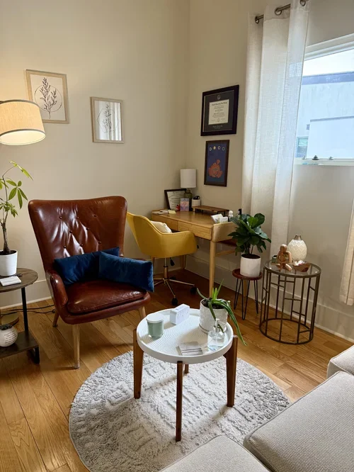 private office rental commercial rental space new orleans leather brown armchair mustard yellow desk chair wooden desk coffee tables white rug framed art natural light commercial boutique
