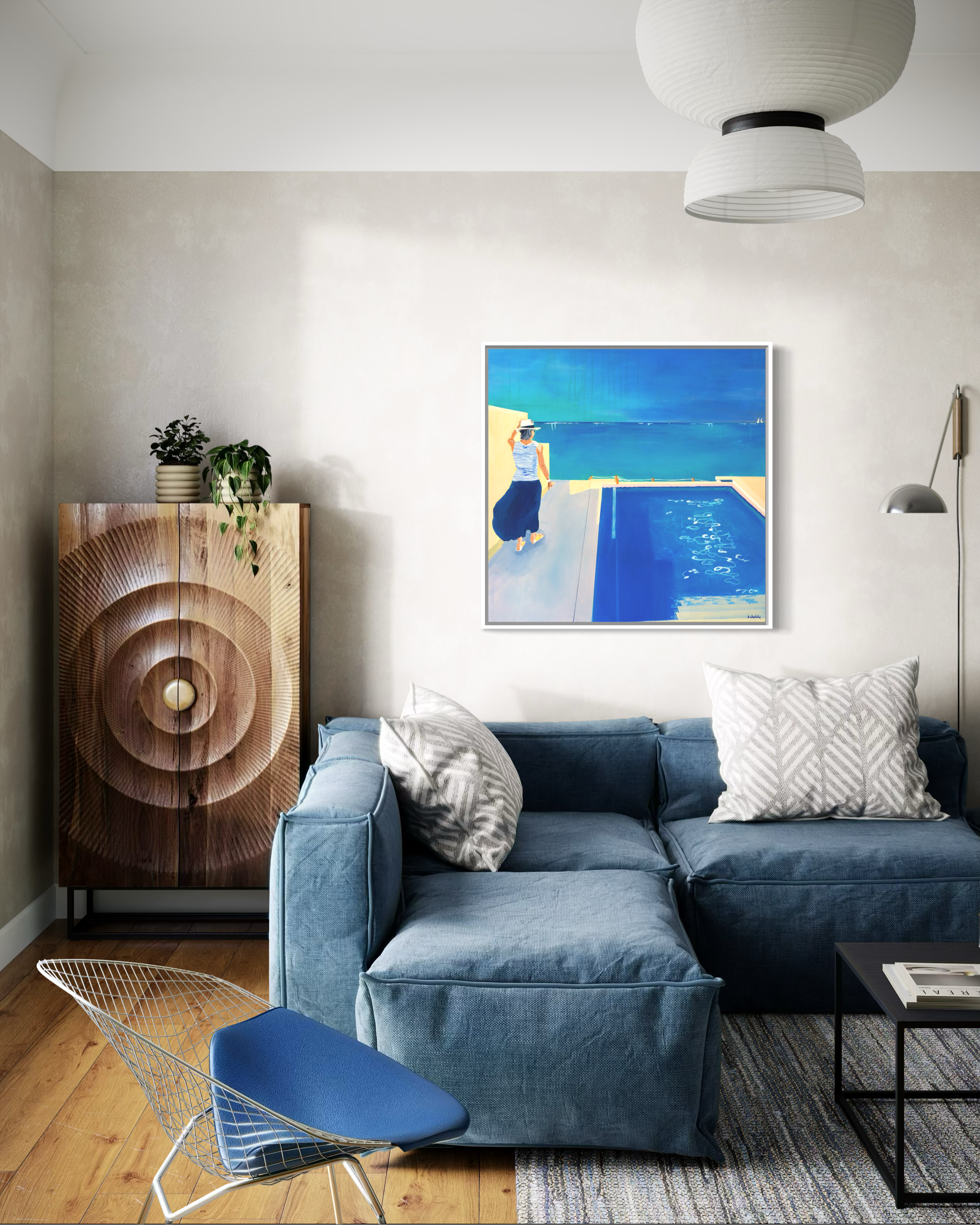 “Bahama Blues” by Anne Whately displayed in a contemporary living room with deep blue modular sofa and contemporary coastal-inspired interior styling.