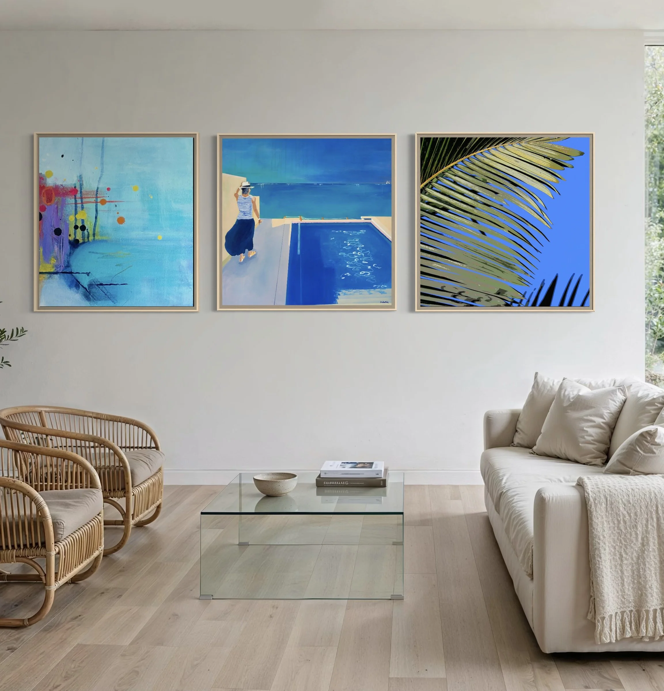 Calm blue and turquoise triptych by Anne Whately in matching timber frames above a neutral sofa in a light contemporary living room.