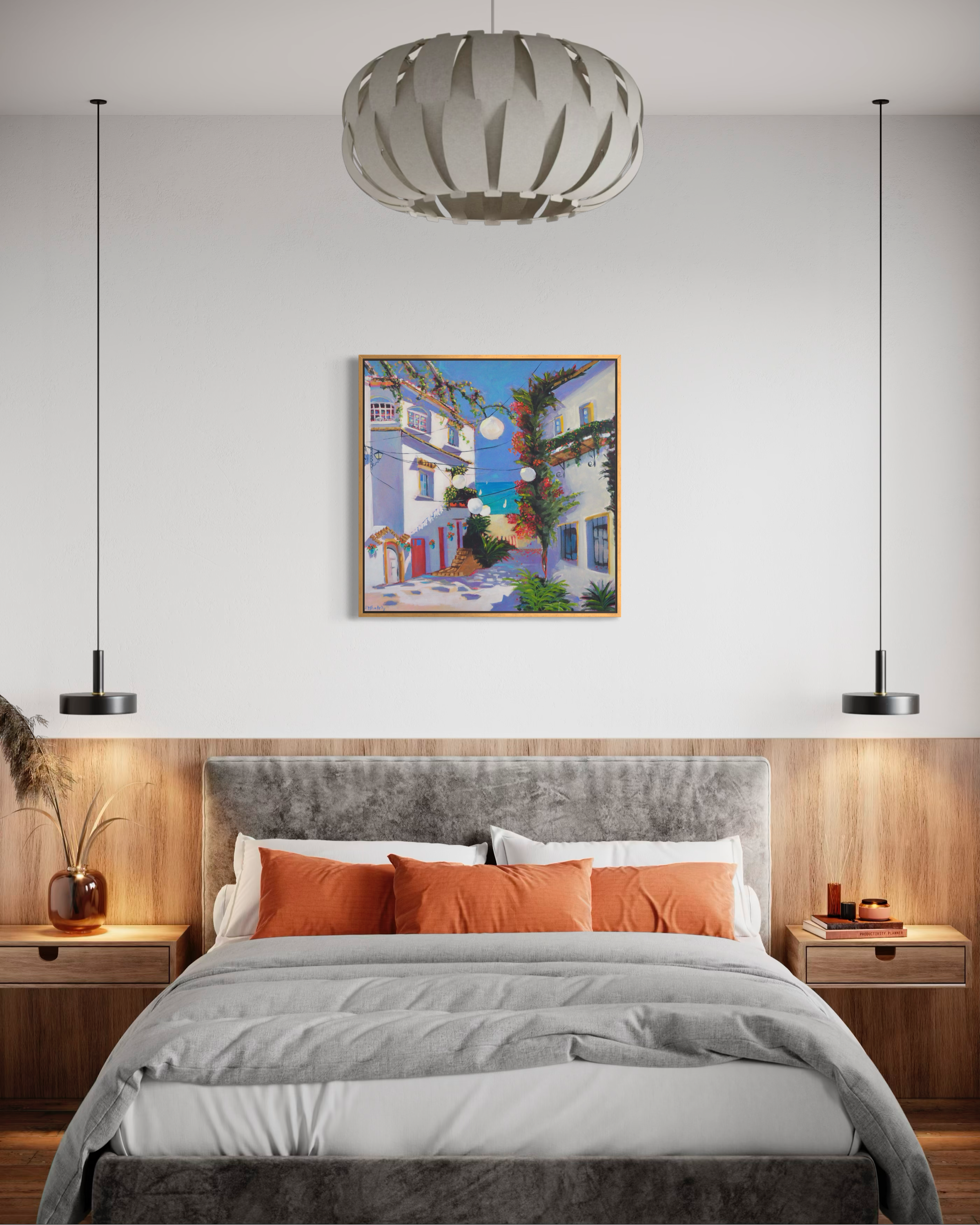 Las Luces painting hanging on a white wall above a bed with orange cushions and modern lights.