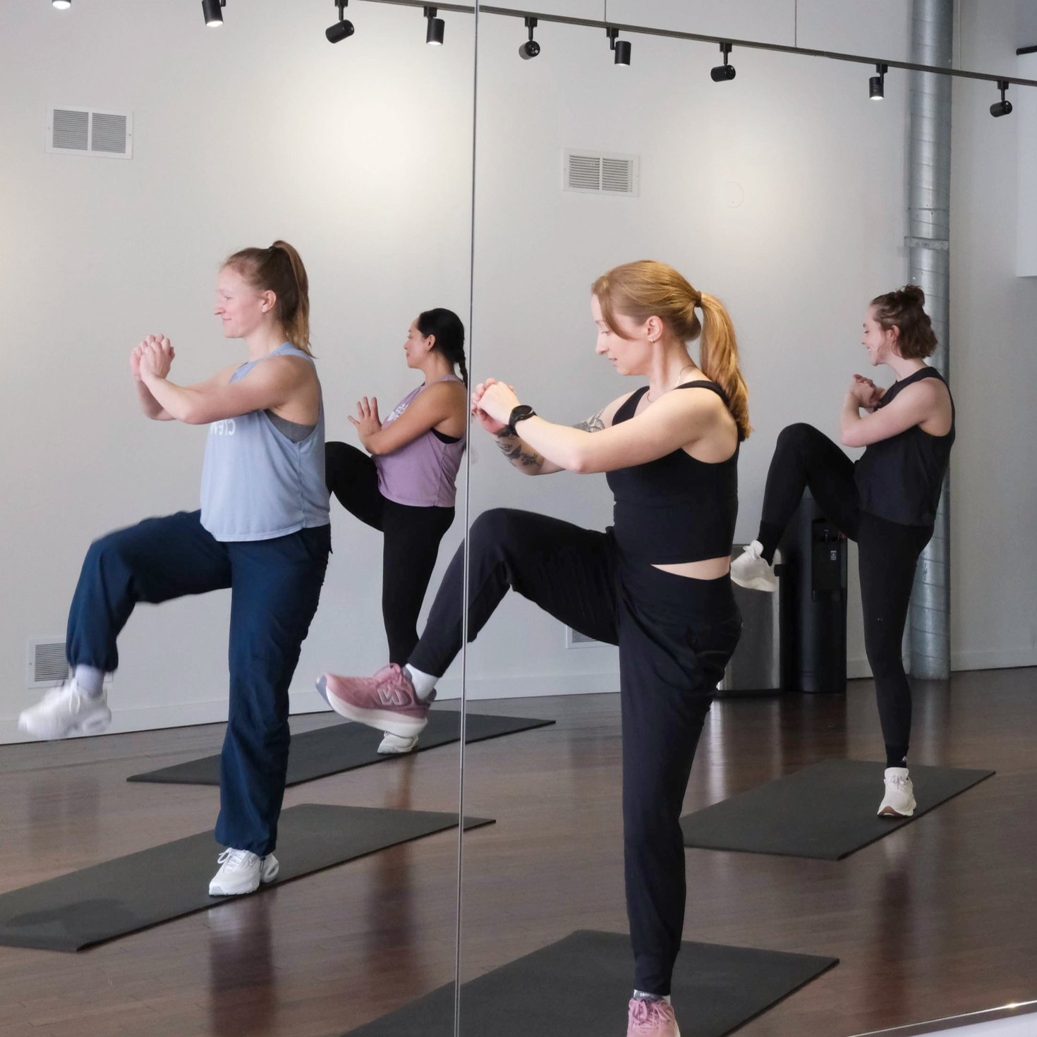 Woman leading a group through intense strength training on yoga mats.