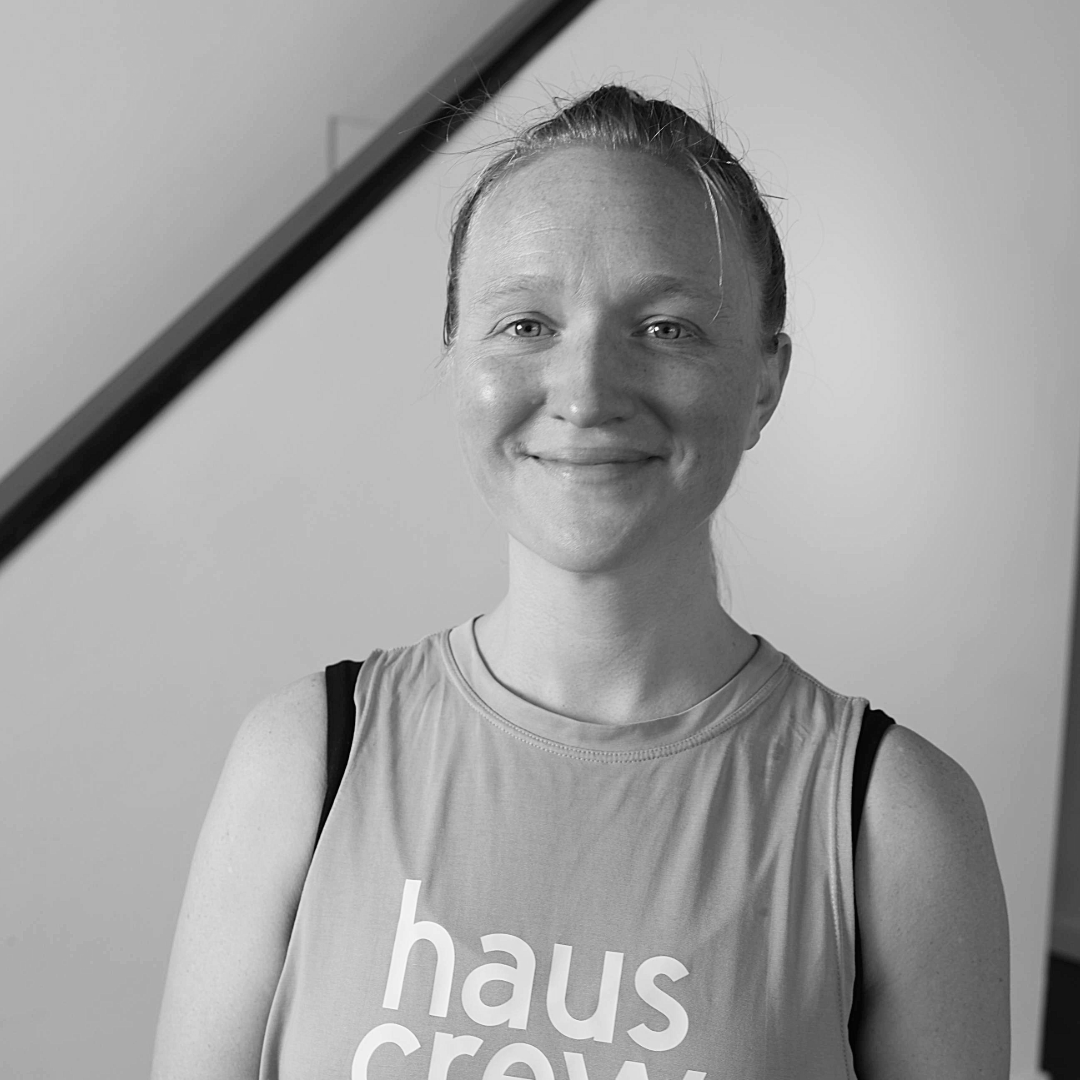 A close up, black and white image of a woman smiling at the camera.