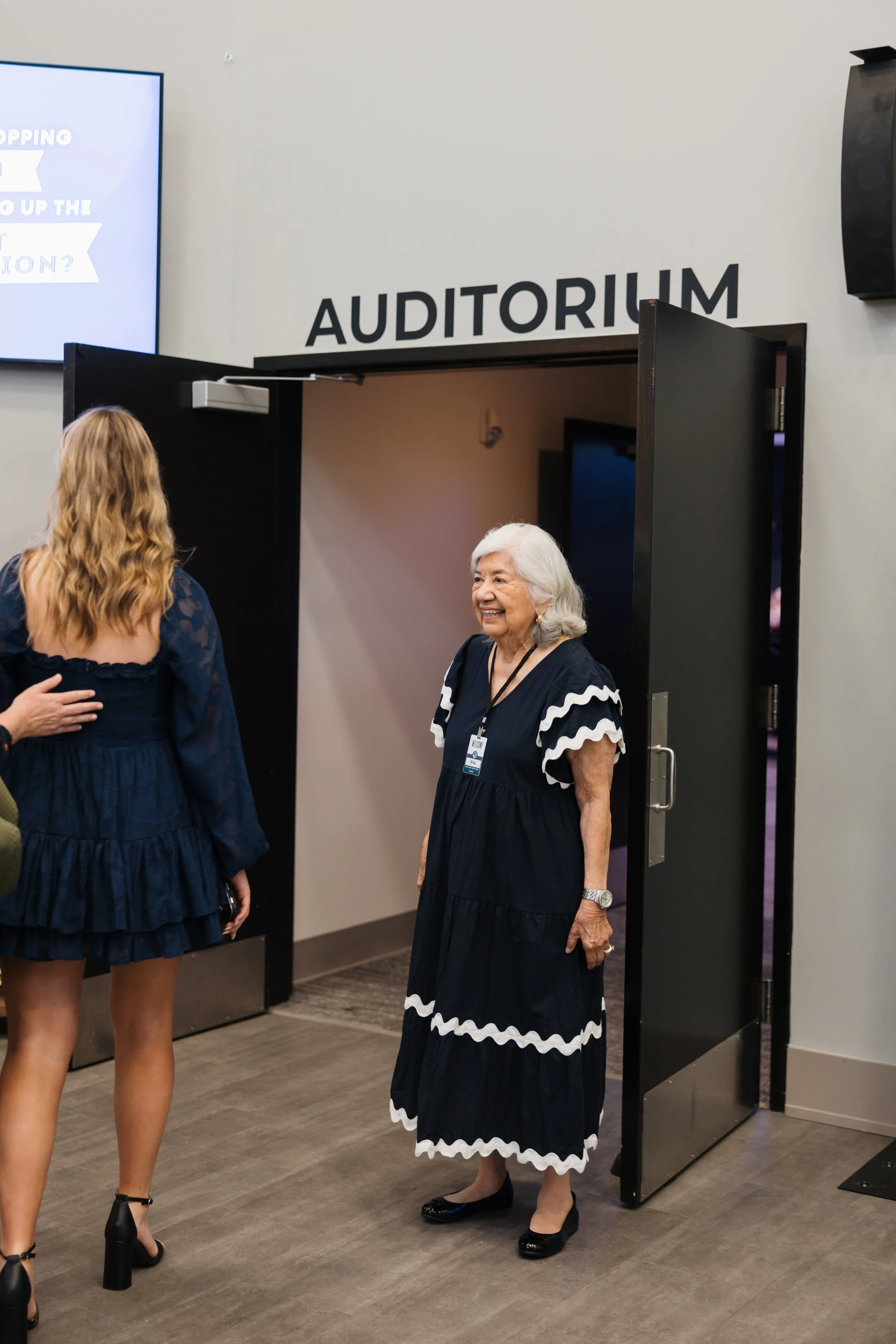 A women welcoming people with a smile at Onward Community Church in Frisco