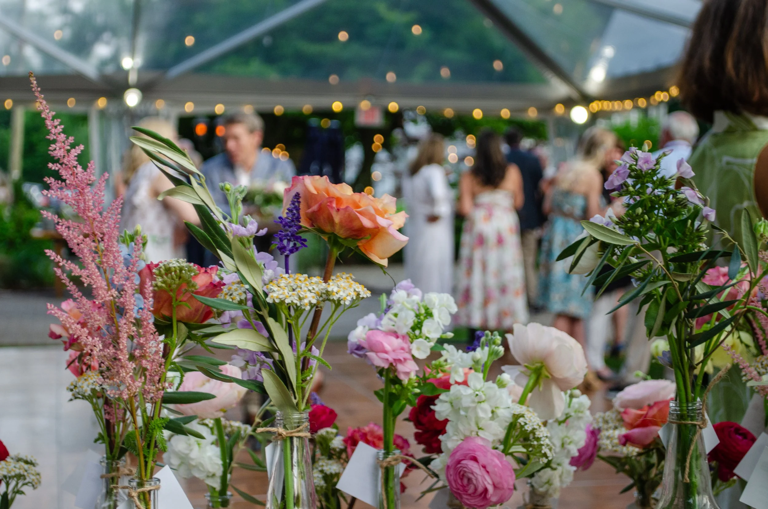 Colorful flower arrangement in vases at a floral display event, photographed by Courtney Main
