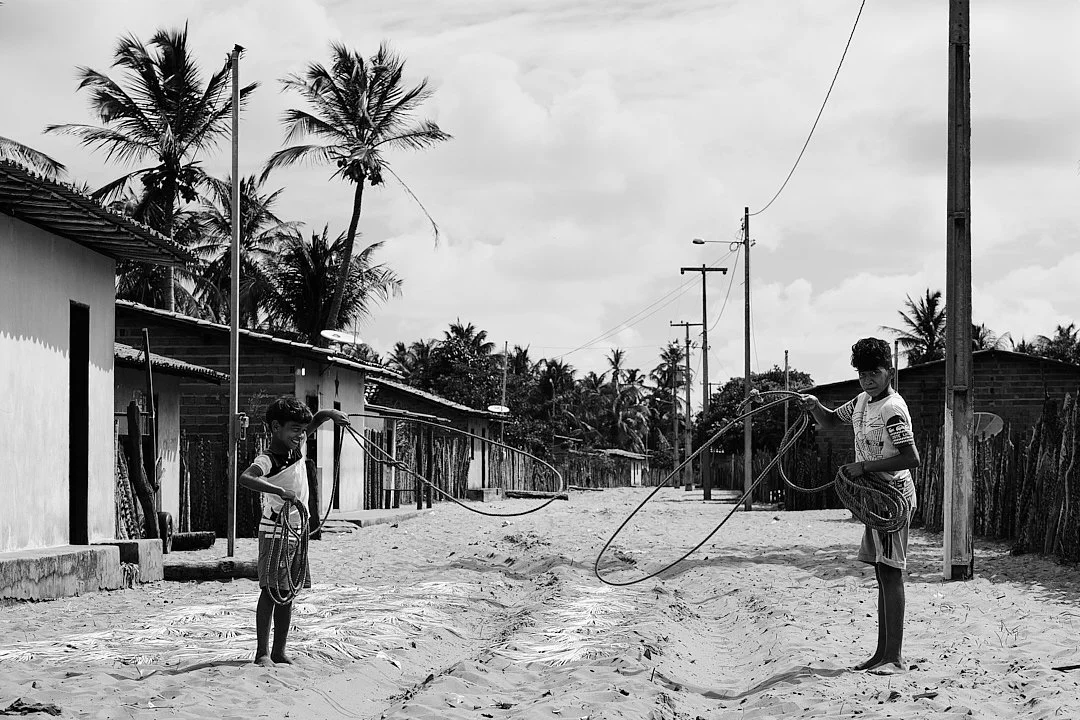 The streets of Travosa are sand. The boys play in them the same way their fathers did, with whatever is at hand. Two of them with lassos in the middle of the road, in no particular hurry, with nowhere else to be. The palm trees do not move. Neither d