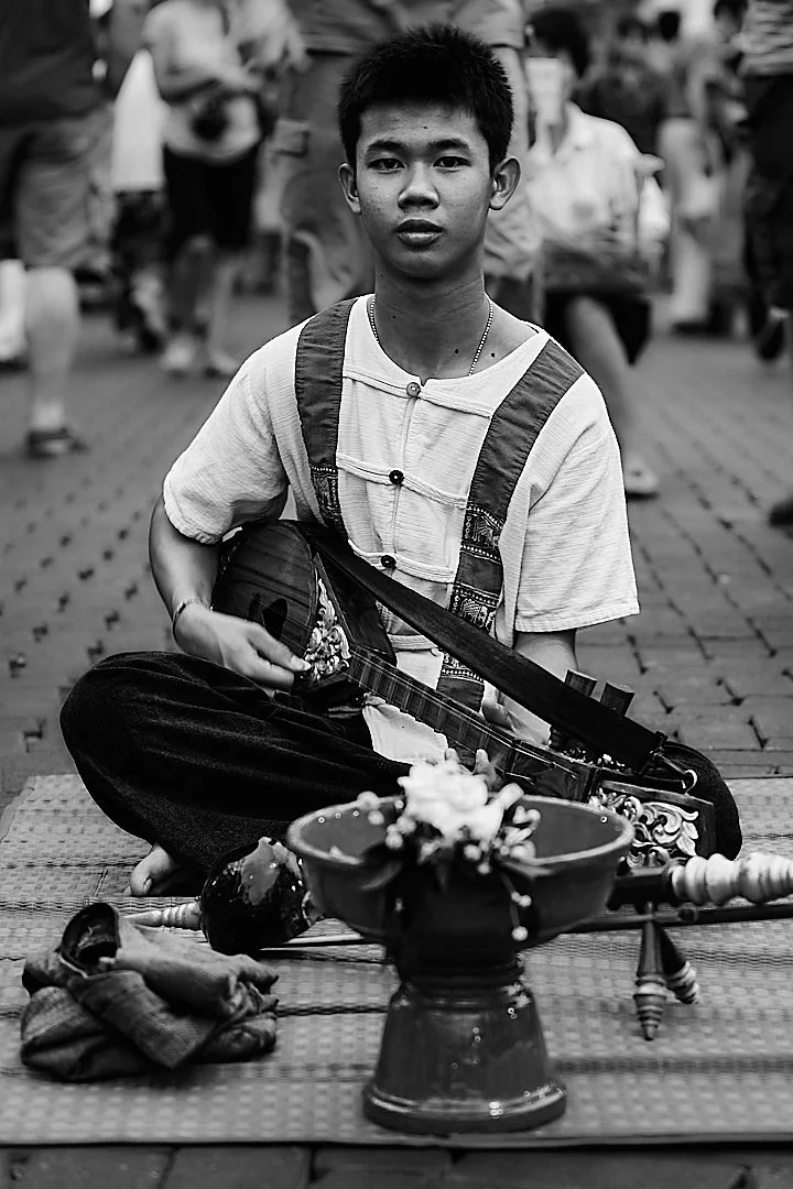 He sat cross legged on the street and played for whoever stopped to listen, which was not many. He did not seem to mind. The music did not require an audience.