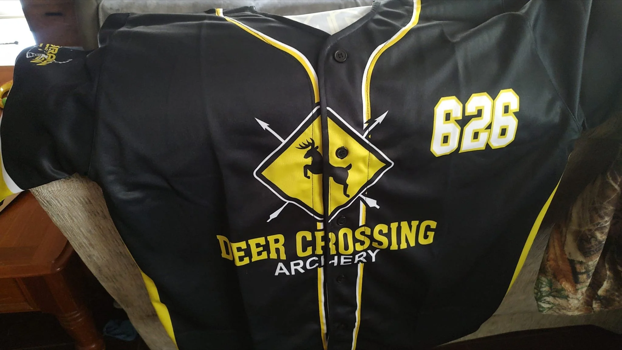 Black and yellow deer crossing archery jersey with the number 626, featuring a deer and crossed arrows design.