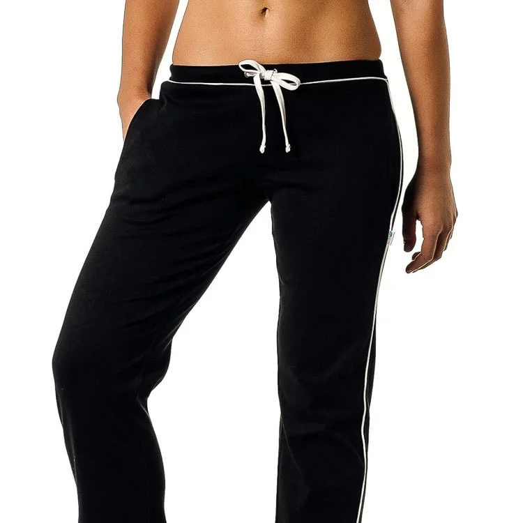 Close-up of a woman's lower torso wearing black athletic track pants with white side piping and a drawstring waistband.