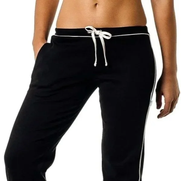 Close-up of a woman's midsection wearing black athletic pants with white drawstring and white side piping.