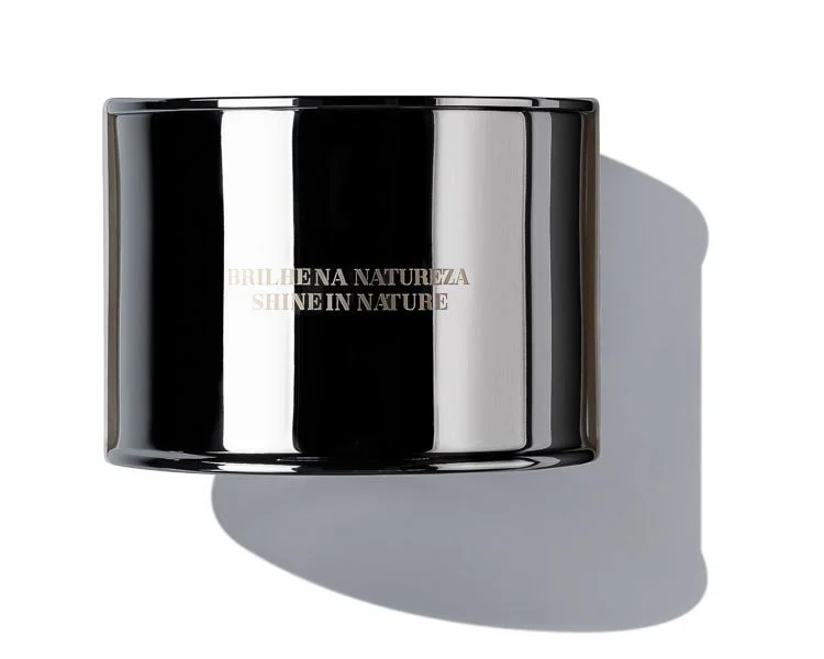 A shiny black container with the words 'BRILLHENA NATUEZA SHINE IN NATURE' printed on it, casting a shadow on a white background.