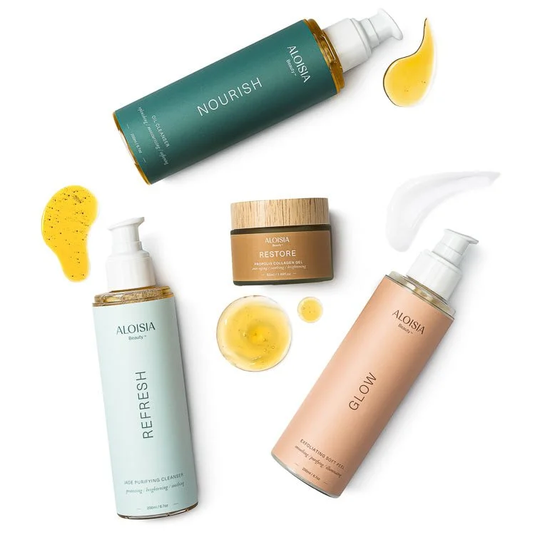 Skincare products from Aloisia, including Nourish, Refresh, Restore, and Glow, displayed with splashes and drops of serum.