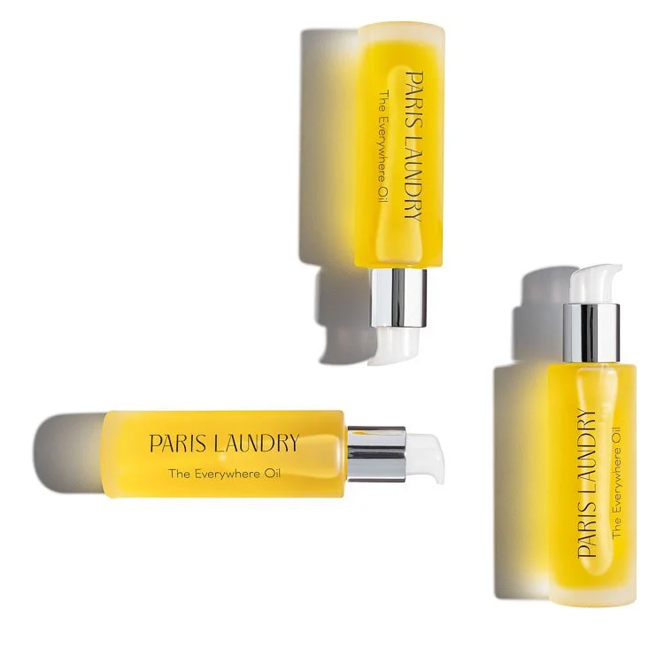 Three bottles of Paris Laundry fragrance oil with yellow liquid, each labeled 'Paris Laundry The Everywhere Oil', against a white background with shadows.