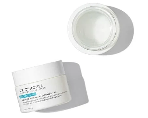 Open jar of Dr. Zenovia skincare cream or gel on white surface, with shadow cast to right.