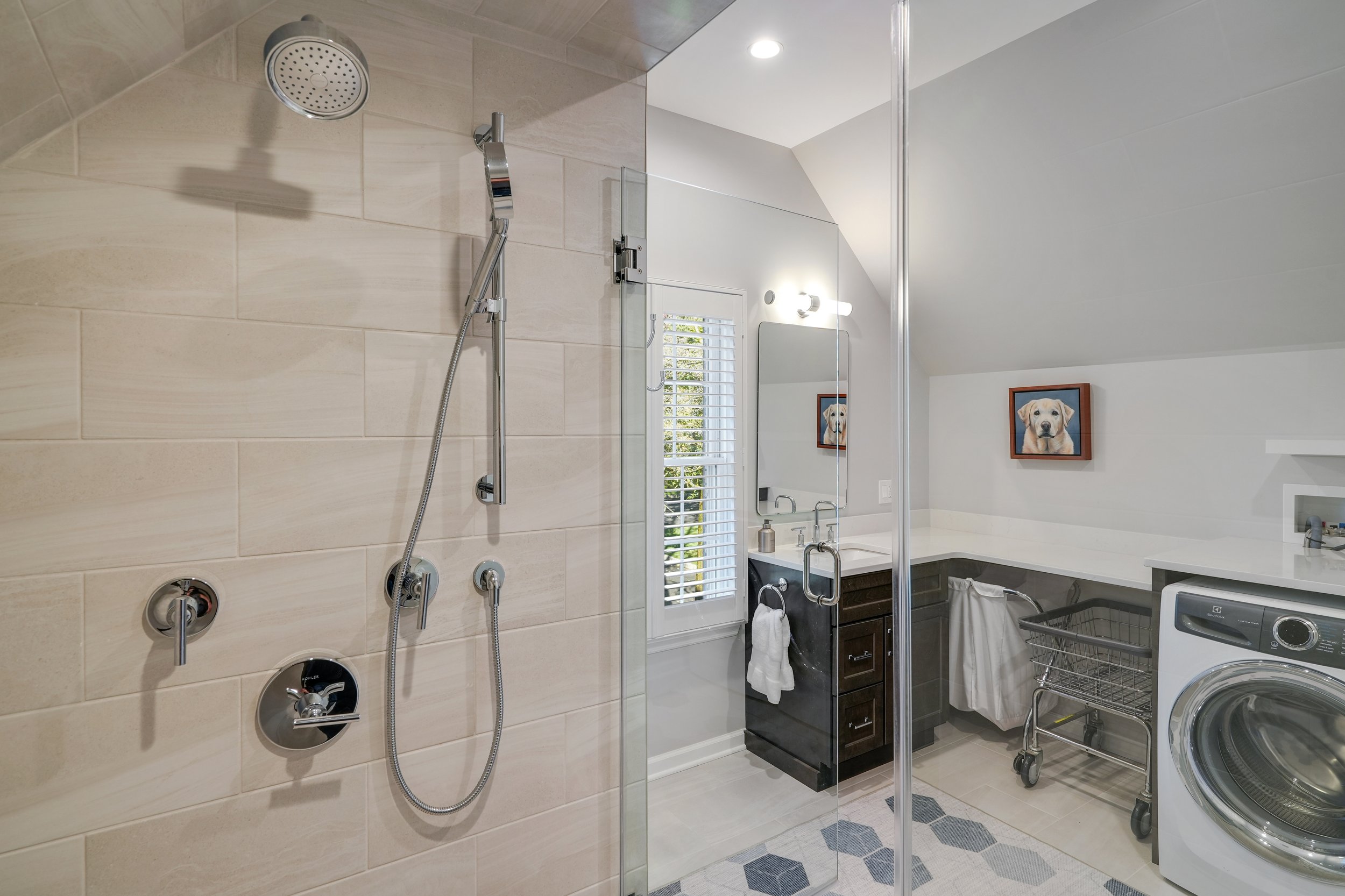 Primary bathroom, double under mount sink, glass shower, soaking tub, mudroom, laundry room, charcoal floor tiles, galley bathroom, light and airy.