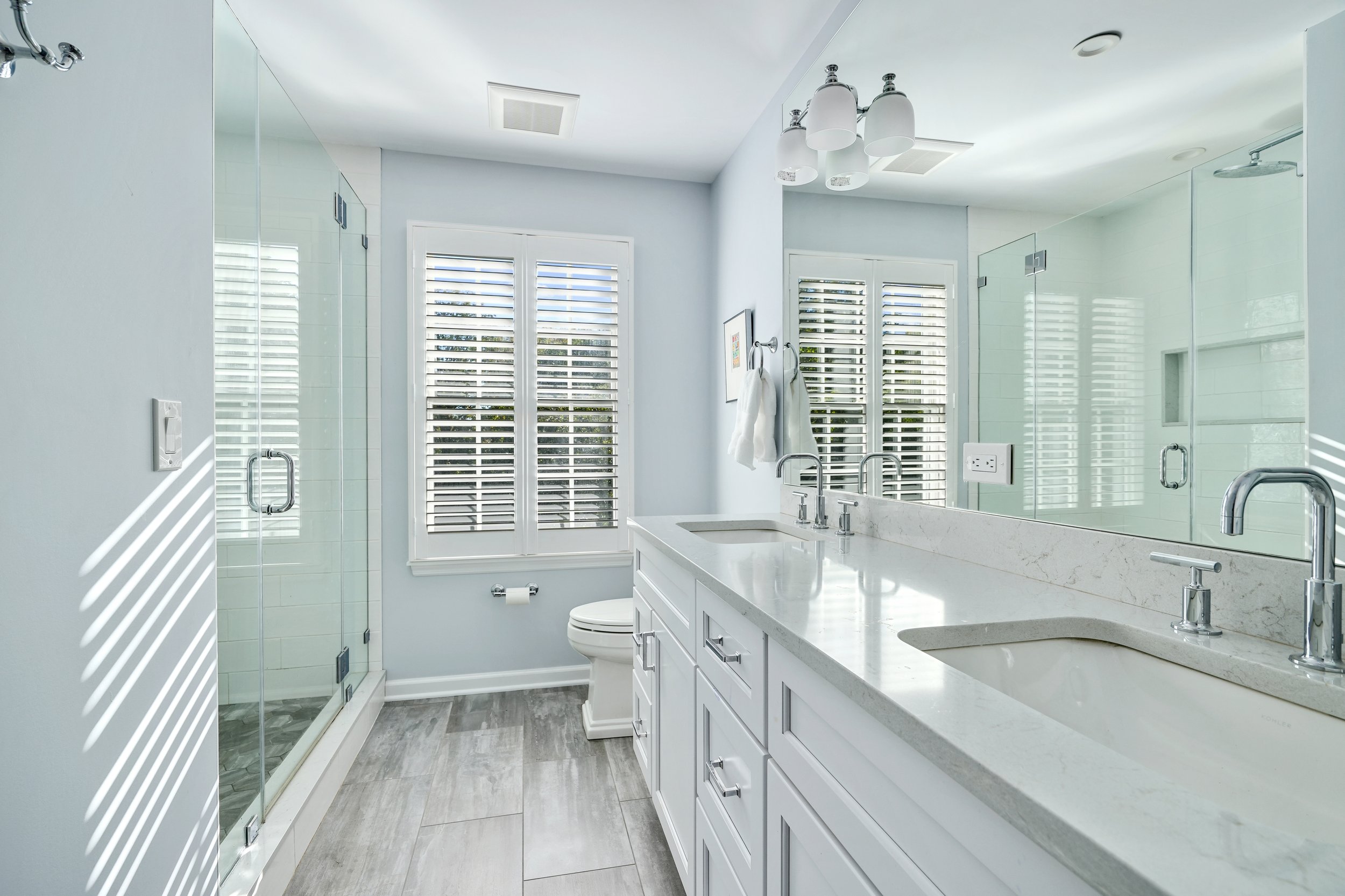 Primary bathroom, double under mount sink, glass shower, soaking tub, mudroom, laundry room, charcoal floor tiles, galley bathroom, light and airy.