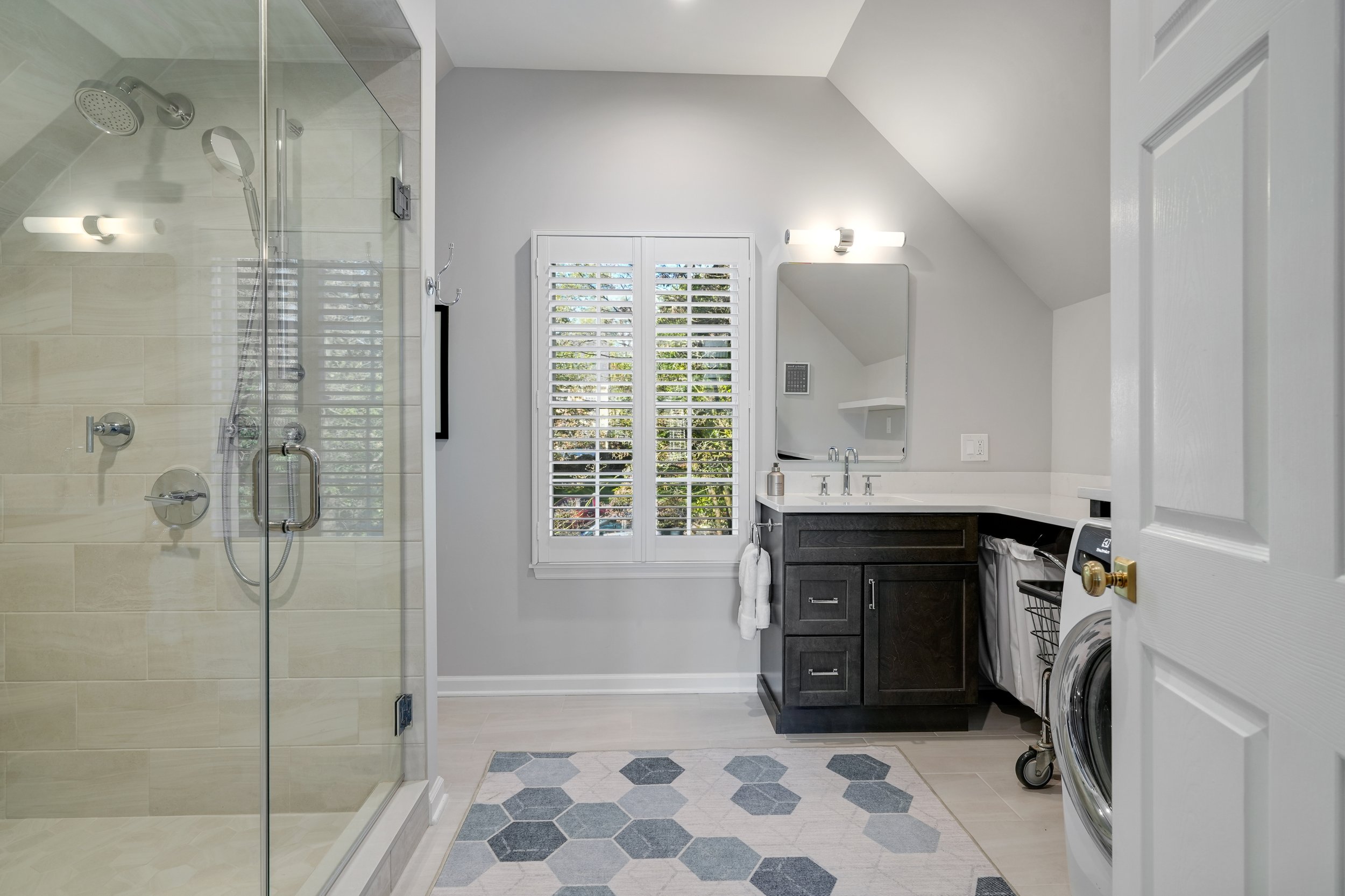 Primary bathroom, double under mount sink, glass shower, soaking tub, mudroom, laundry room, charcoal floor tiles, galley bathroom, light and airy.