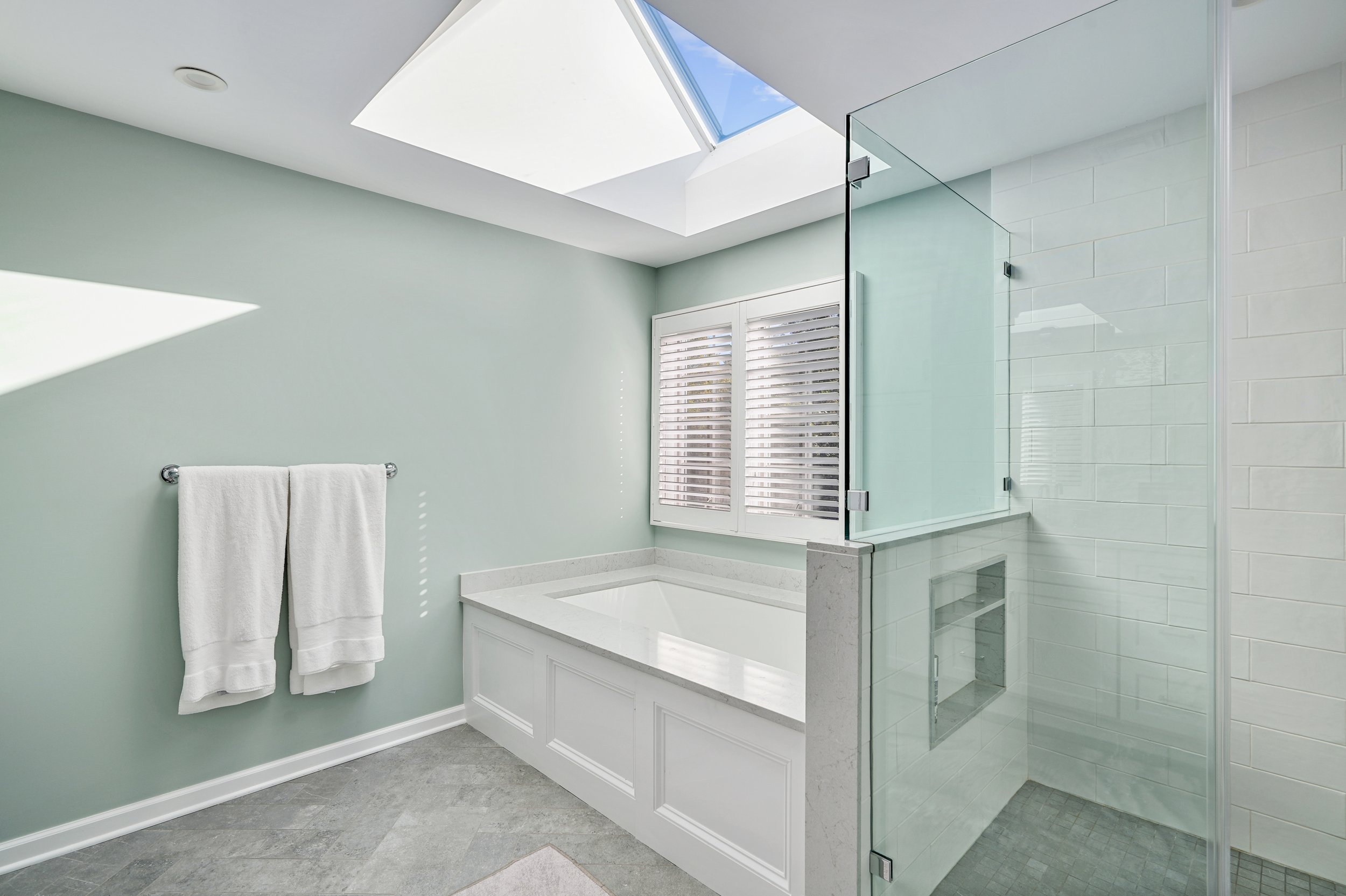 Primary bathroom, double under mount sink, glass shower, soaking tub, mudroom, laundry room, charcoal floor tiles, galley bathroom, light and airy.