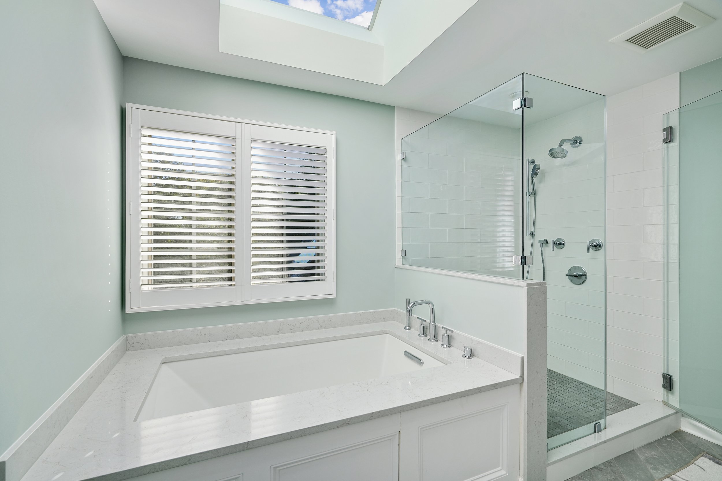 Primary bathroom, double under mount sink, glass shower, soaking tub, mudroom, laundry room, charcoal floor tiles, galley bathroom, light and airy.