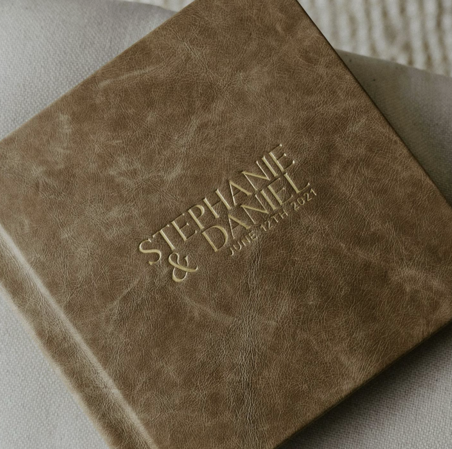 A tan leather box with gold embossed text reading "STEPHANIE & DAVID JANUARY 22ND, 2022."