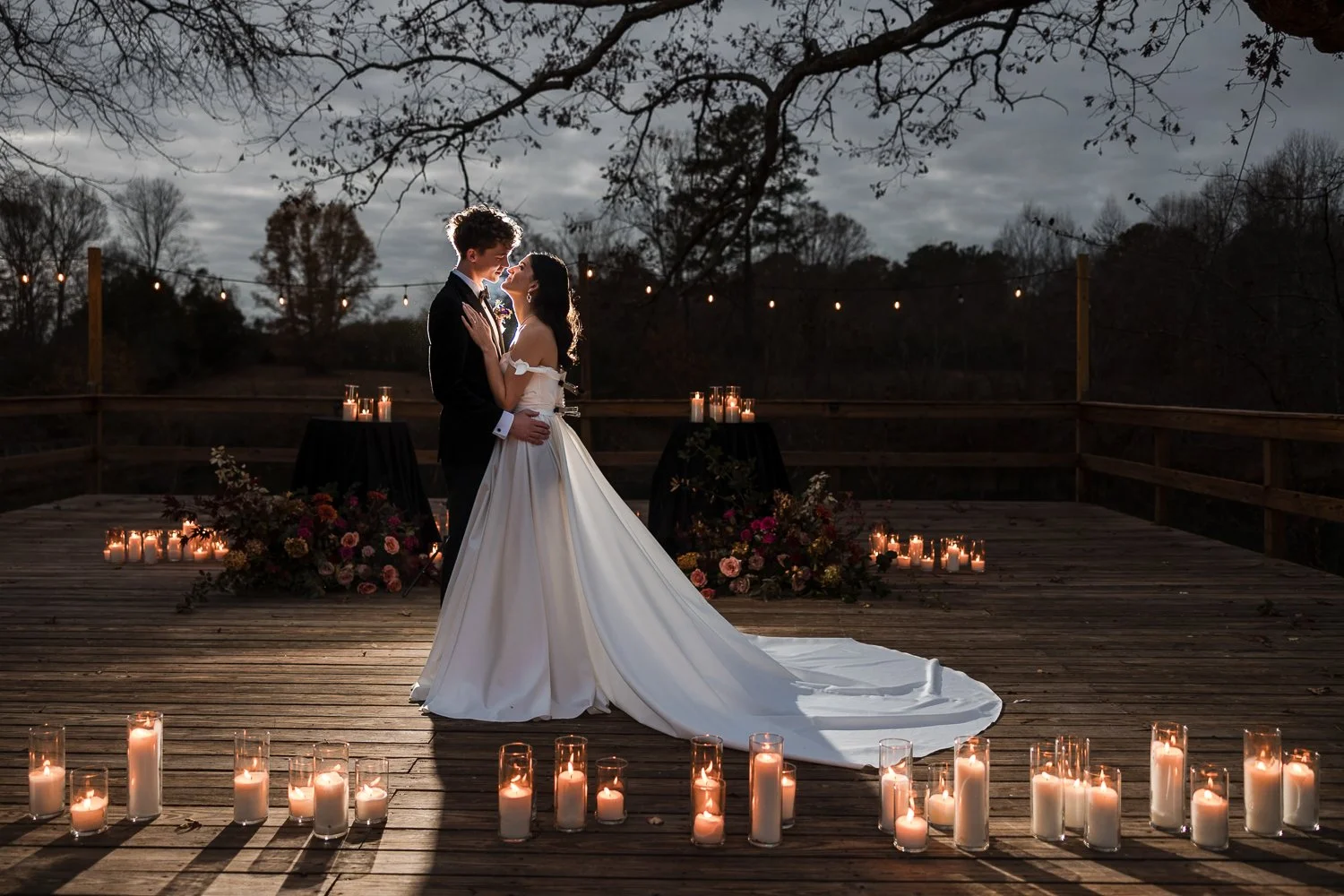 North Atlanta wedding photo of a couple kissing, candle light around them and beautiful flowers behind them