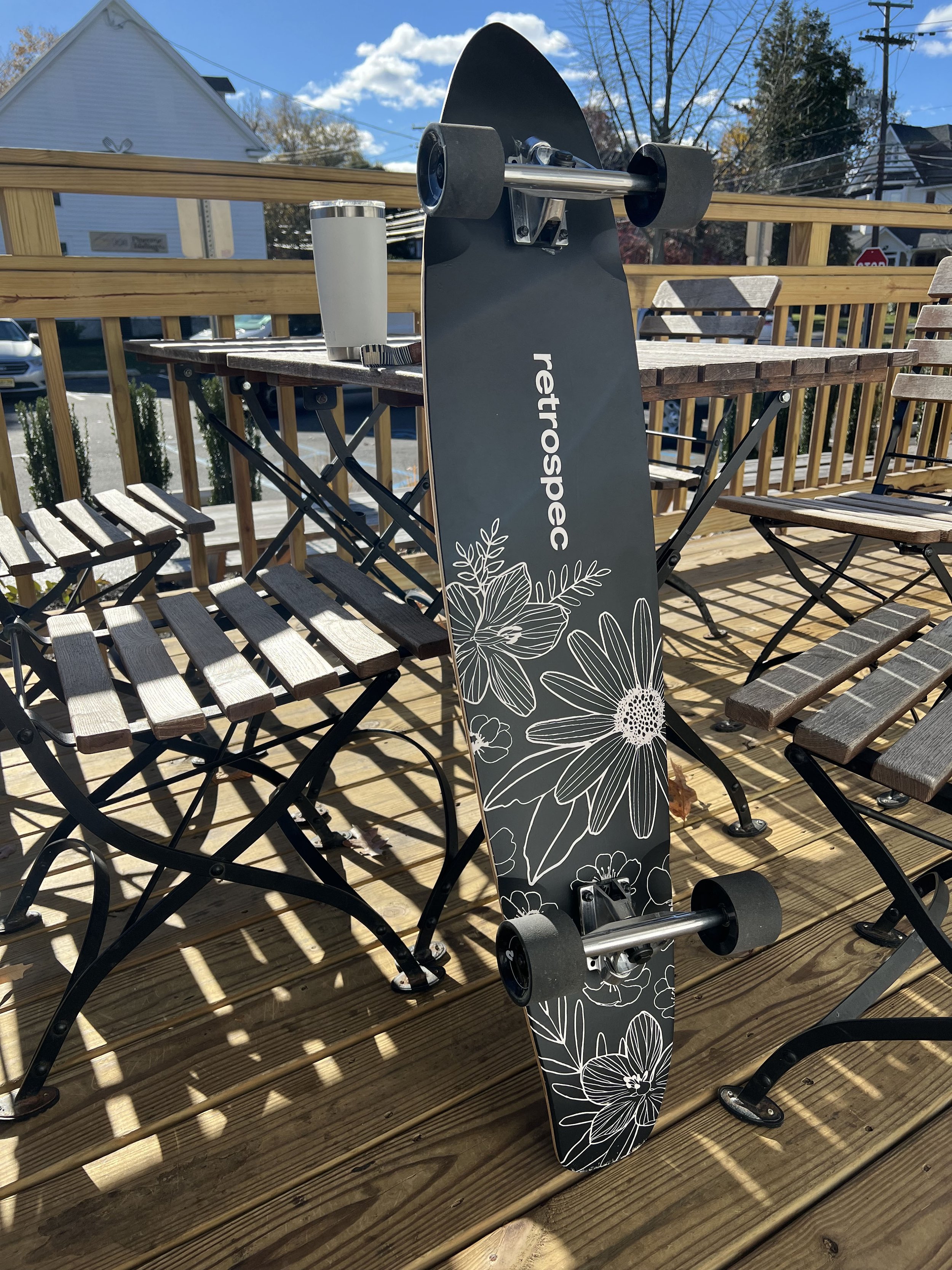 Boho Florals Retropec Zed longboard propped against a table