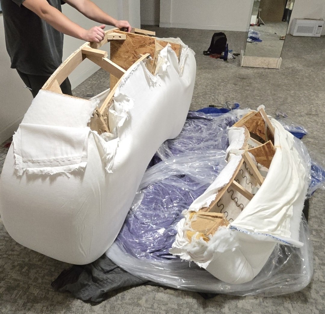 Furniture specialists moving oversized couches through elevators